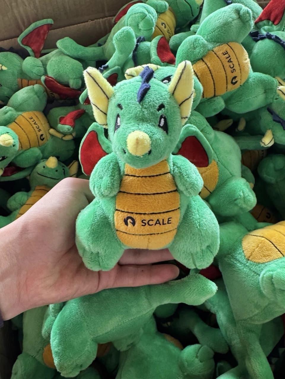 Peluche de mascota de marca con forma de dragón y logotipo de empresa bordado