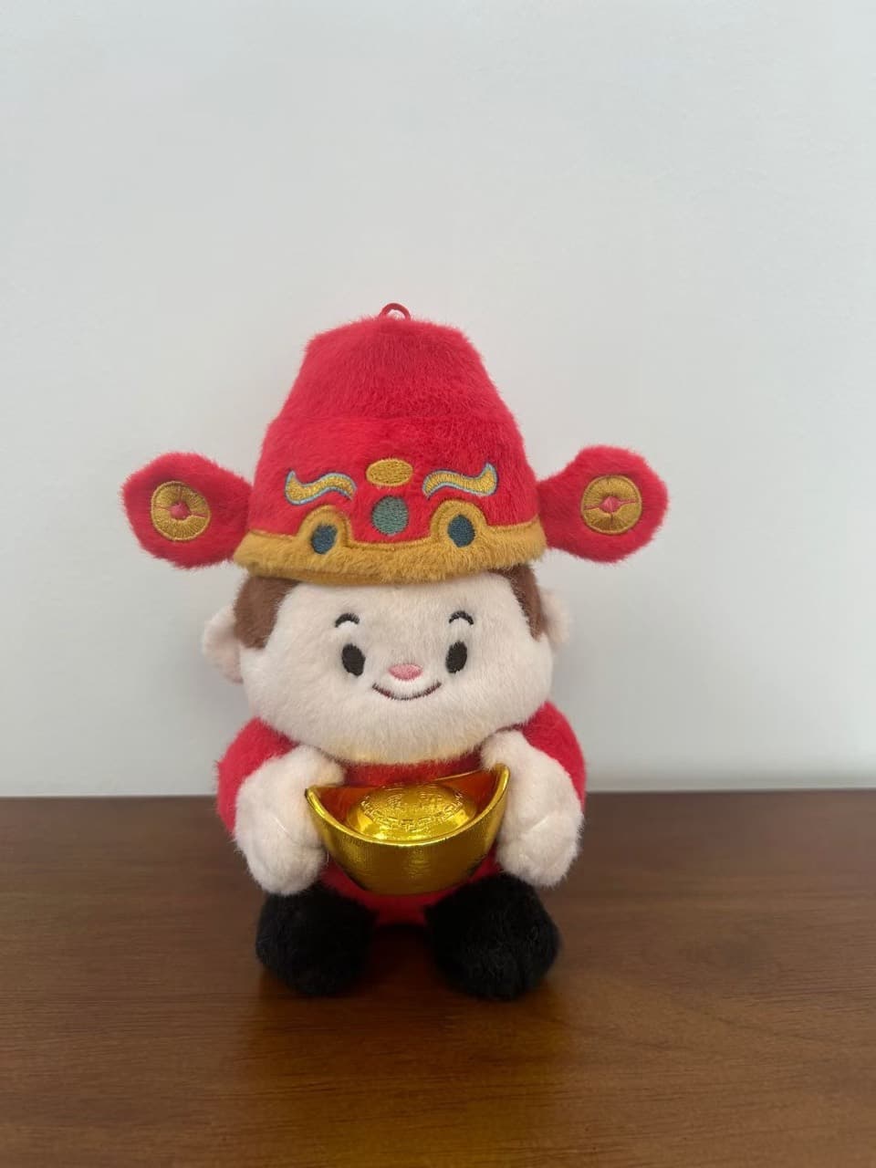 Peluche de mascota del Dios de la Riqueza sosteniendo un lingote de oro
