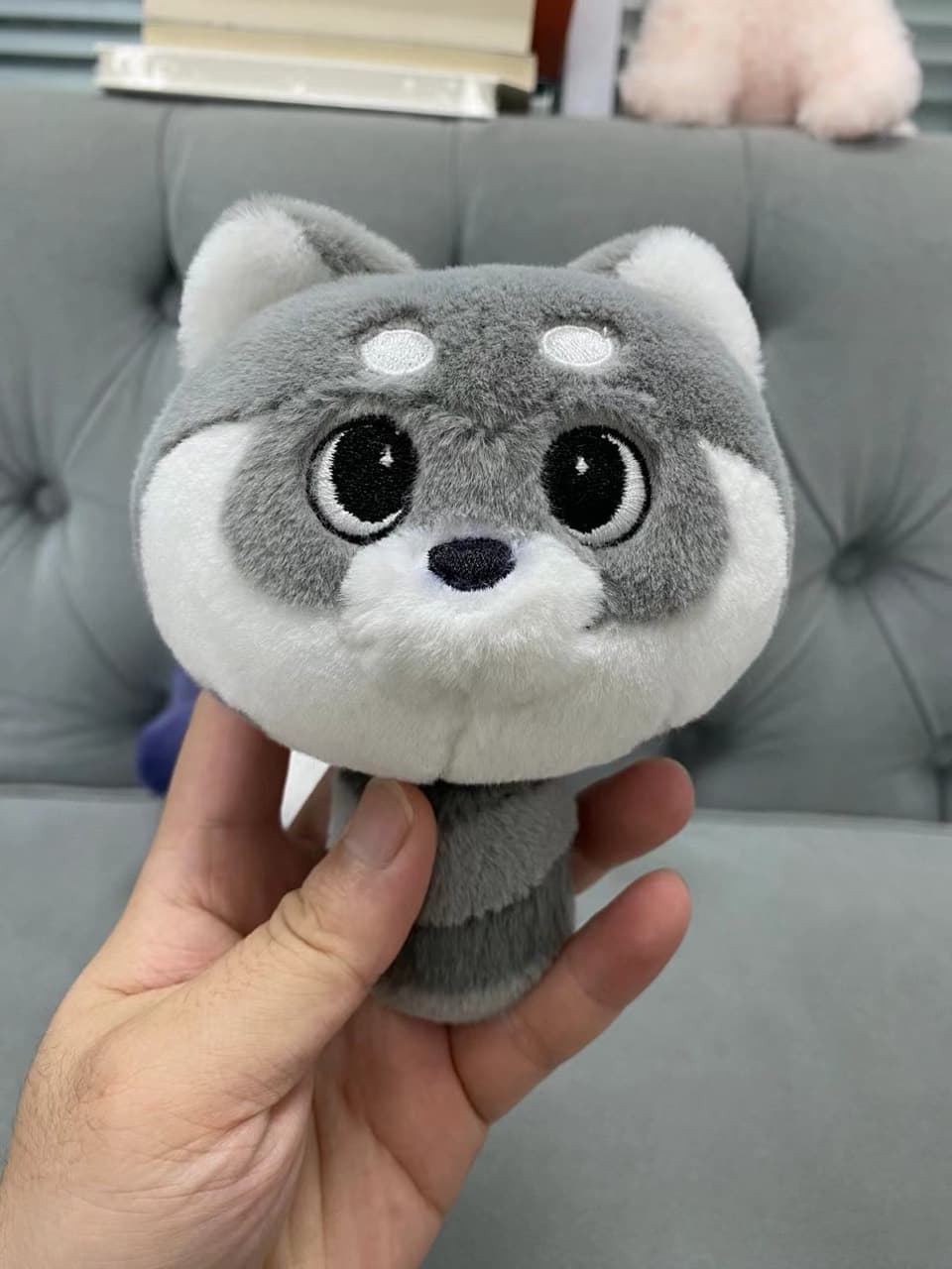 Peluche de mapache gris con ojos grandes